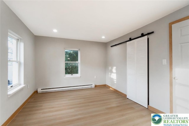 226 Fern St, Jim Thorpe Boro, PA 18229 - unfurnished bedroom featuring a baseboard heating unit, a barn door, light wood-type flooring, multiple windows, and recessed lighting