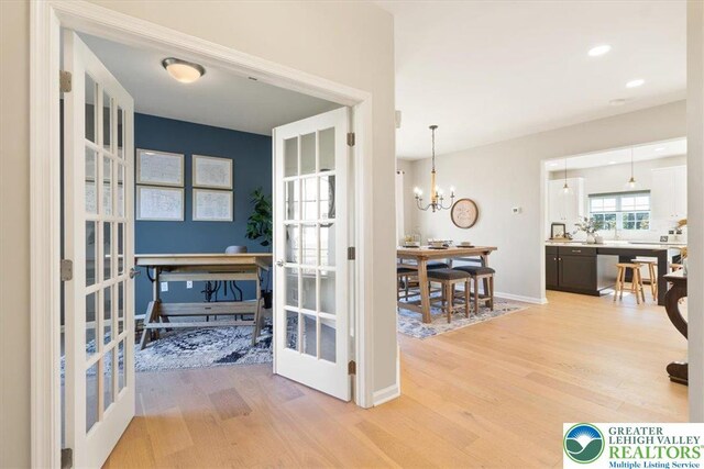 77 Tumble Creek Rd Unit 14, Williams Twp, PA 18042 - hallway featuring french doors, light wood finished floors, and a chandelier