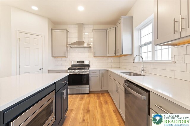 77 Tumble Creek Rd Unit 14, Williams Twp, PA 18042 - kitchen featuring appliances with stainless steel finishes, wall chimney range hood, light countertops, light wood finished floors, and recessed lighting