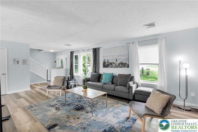 672 Clearview St, Tobyhanna Twp, PA 18334 - living area featuring stairway, light wood-style flooring, and a textured ceiling