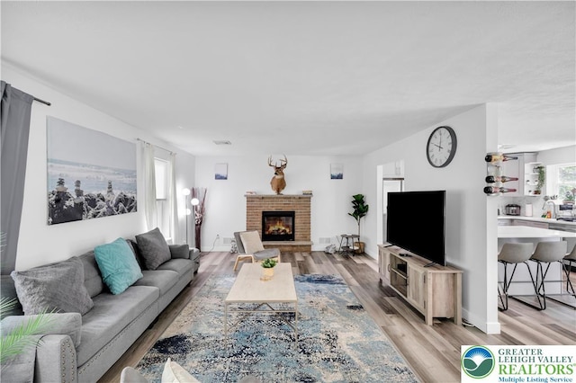 672 Clearview St, Tobyhanna Twp, PA 18334 - living area featuring light wood-type flooring and a brick fireplace