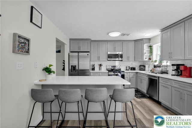 672 Clearview St, Tobyhanna Twp, PA 18334 - kitchen with appliances with stainless steel finishes, gray cabinets, a kitchen bar, and a peninsula