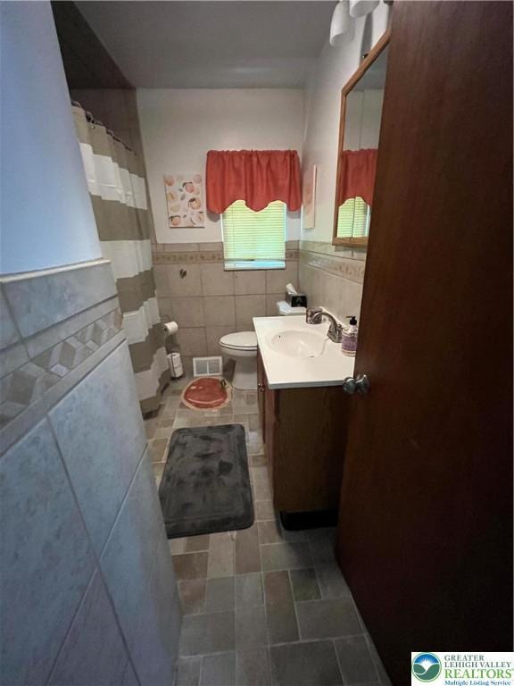 1321 Sheridan Rd, Lower Milford Twp, PA 18036 - full bathroom with tile walls, vanity, a wainscoted wall, tile patterned flooring, and curtained shower