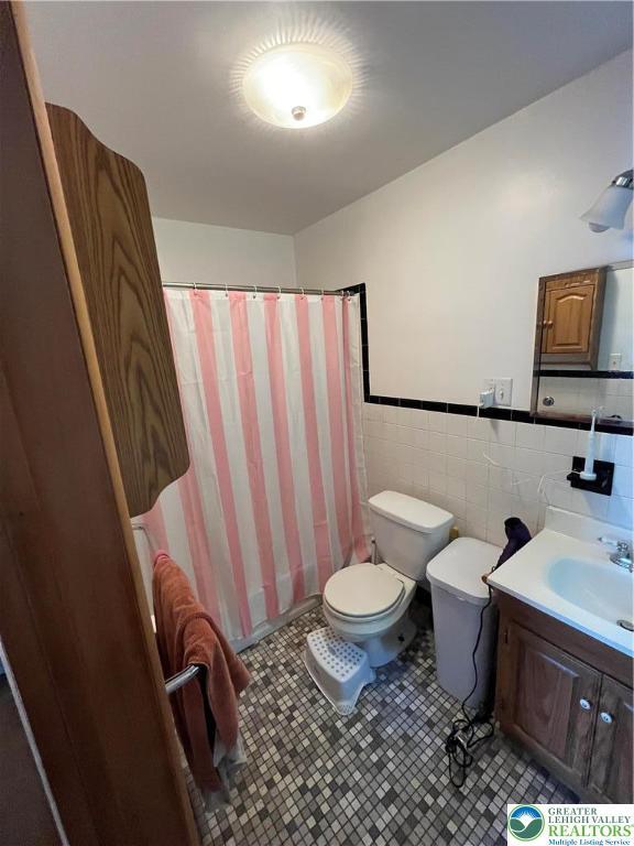 1321 Sheridan Rd, Lower Milford Twp, PA 18036 - bathroom with vanity, curtained shower, tile walls, and wainscoting