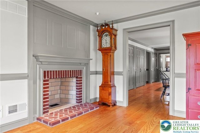 6513 Station Vw, Upper Milford Twp, PA 18092 - unfurnished living room featuring light wood-type flooring, crown molding, and a fireplace