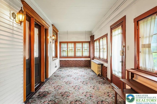 2834 Interchange Rd, Franklin Twp, PA 18235 - unfurnished sunroom featuring brick wall, radiator heating unit, carpet floors, and crown molding