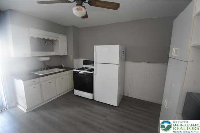 817 Ridge St, Easton, PA 18042 - kitchen with white appliances, dark wood-style flooring, ceiling fan, a wainscoted wall, and white cabinetry