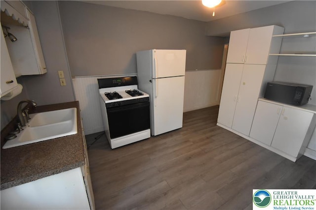 817 Ridge St, Easton, PA 18042 - kitchen featuring white appliances, a wainscoted wall, dark wood-style floors, white cabinets, and dark countertops