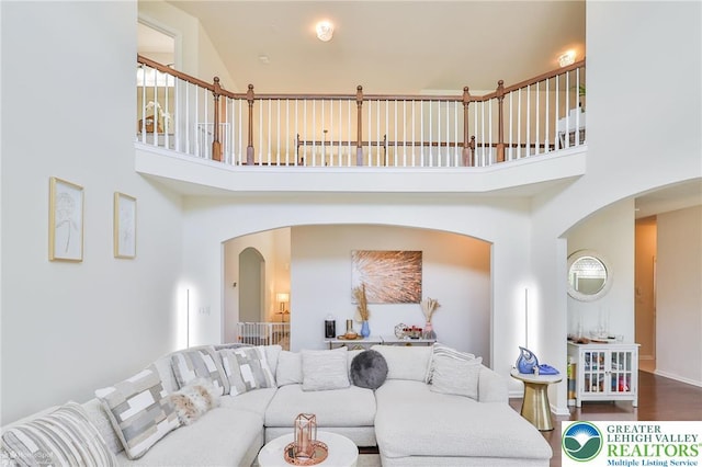 249 Danbury Dr, Upper Nazareth Twp, PA 18064 - living room featuring a high ceiling, arched walkways, and wood finished floors
