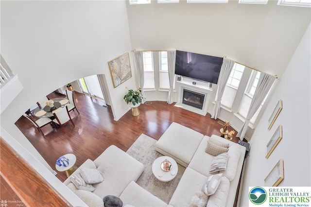 249 Danbury Dr, Upper Nazareth Twp, PA 18064 - living area featuring a towering ceiling, wood finished floors, a fireplace with flush hearth, and arched walkways