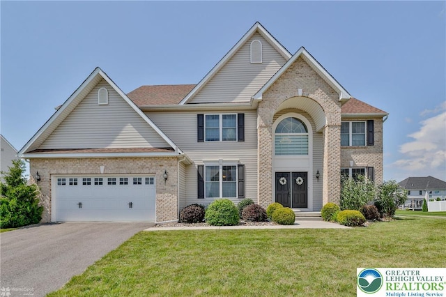 249 Danbury Dr, Upper Nazareth Twp, PA 18064 - traditional-style home with brick siding, asphalt driveway, a front yard, and an attached garage