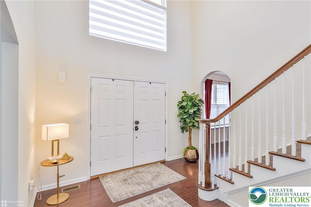 249 Danbury Dr, Upper Nazareth Twp, PA 18064 - entrance foyer featuring arched walkways, a towering ceiling, wood finished floors, and stairway
