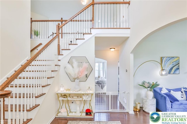 249 Danbury Dr, Upper Nazareth Twp, PA 18064 - staircase with arched walkways, a towering ceiling, and wood finished floors