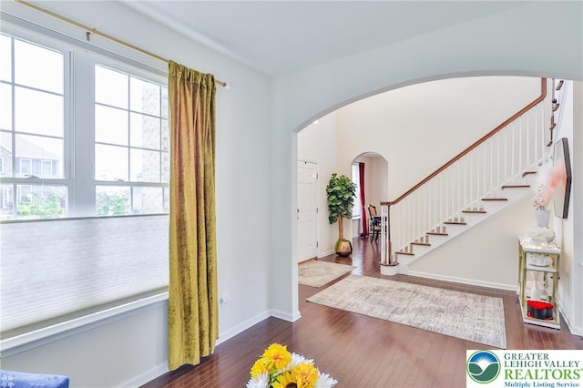 249 Danbury Dr, Upper Nazareth Twp, PA 18064 - entrance foyer with stairway, arched walkways, and dark wood finished floors