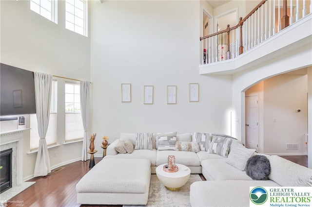 249 Danbury Dr, Upper Nazareth Twp, PA 18064 - living area featuring a towering ceiling, arched walkways, healthy amount of natural light, wood finished floors, and a fireplace