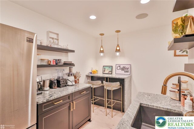 249 Danbury Dr, Upper Nazareth Twp, PA 18064 - bar area featuring freestanding refrigerator, recessed lighting, decorative light fixtures, and light marble finish flooring
