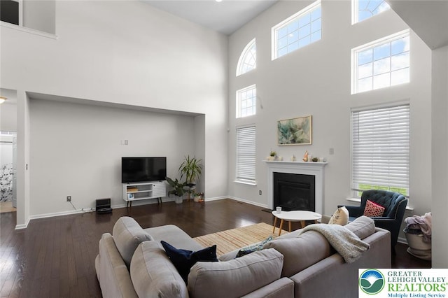 237 Danbury Dr, Upper Nazareth Twp, PA 18064 - living area with a high ceiling, dark wood finished floors, and a glass covered fireplace