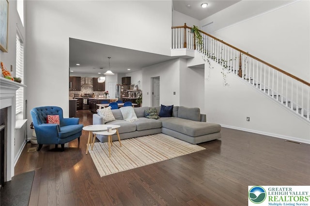 237 Danbury Dr, Upper Nazareth Twp, PA 18064 - living room with a towering ceiling, a fireplace with flush hearth, dark wood-style flooring, stairway, and recessed lighting