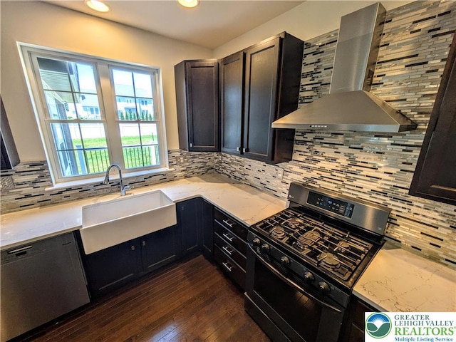 237 Danbury Dr, Upper Nazareth Twp, PA 18064 - kitchen featuring wall chimney range hood, stainless steel appliances, decorative backsplash, dark wood-style floors, and recessed lighting