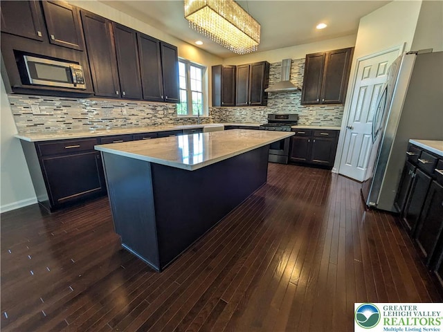 237 Danbury Dr, Upper Nazareth Twp, PA 18064 - kitchen featuring wall chimney exhaust hood, stainless steel appliances, dark wood finished floors, a kitchen island, and decorative backsplash