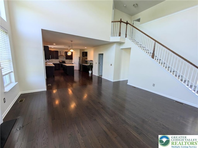 237 Danbury Dr, Upper Nazareth Twp, PA 18064 - living area featuring dark wood-style floors, a towering ceiling, and stairway