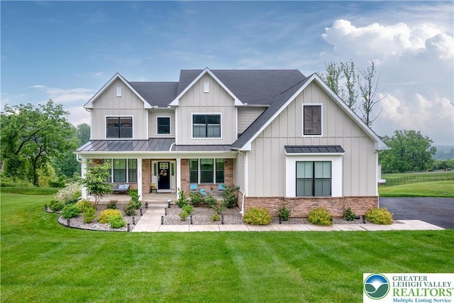 5635 Saucon Ridge Rd, Upper Saucon Twp, PA 18036 - modern inspired farmhouse featuring a standing seam roof, covered porch, a front yard, a metal roof, and a shingled roof