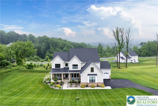 5635 Saucon Ridge Rd, Upper Saucon Twp, PA 18036 - modern farmhouse style home with a porch, board and batten siding, a front lawn, asphalt driveway, and an attached garage