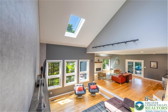 1488 Shelburne Ct, South Whitehall Twp, PA 18104 - living room featuring a skylight, wood finished floors, high vaulted ceiling, a large fireplace, and track lighting