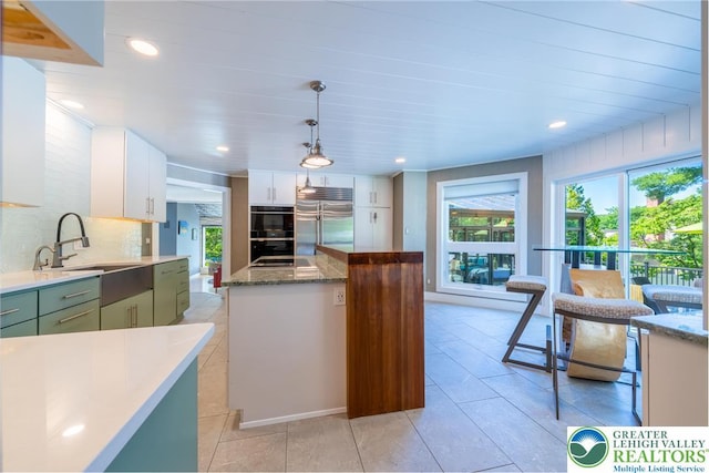 1488 Shelburne Ct, South Whitehall Twp, PA 18104 - kitchen featuring stainless steel built in refrigerator, decorative backsplash, a center island, green cabinetry, and white cabinets