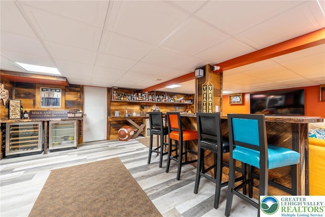 1488 Shelburne Ct, South Whitehall Twp, PA 18104 - indoor bar featuring beverage cooler, wood finished floors, a drop ceiling, and wooden walls