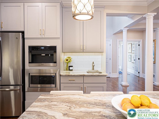 2063 Forge Run, Bethlehem City, PA 18015 - kitchen featuring appliances with stainless steel finishes, ornate columns, light stone countertops, decorative backsplash, and crown molding