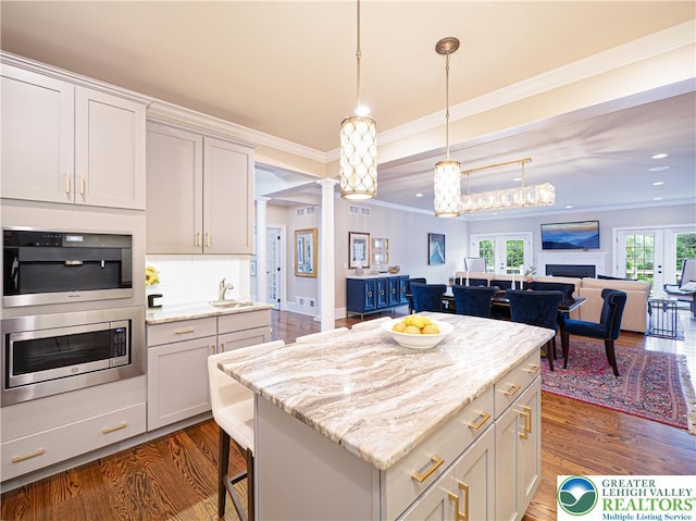 2063 Forge Run, Bethlehem City, PA 18015 - kitchen featuring decorative columns, dark wood-type flooring, a kitchen island, open floor plan, and crown molding