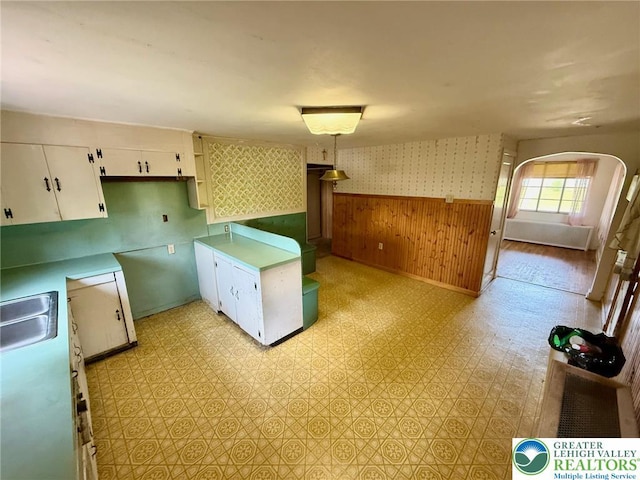 1818 W Jane St, South Whitehall Twp, PA 18104 - kitchen featuring wainscoting, wood walls, white cabinetry, light flooring, and light countertops