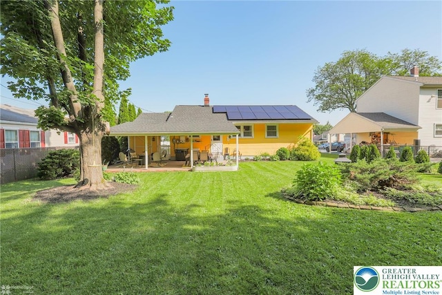 4306 Emerick Ter, Easton, PA 18045 - rear view of house with roof mounted solar panels, a patio area, and a chimney