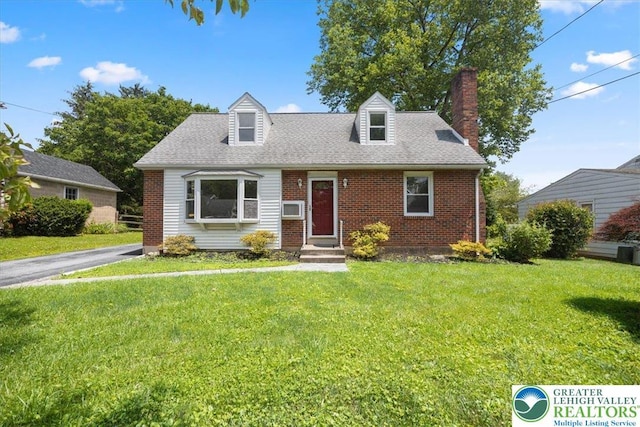 803 Stones Crossing Rd, Palmer Twp, PA 18045 - cape cod house featuring a chimney, a front yard, brick siding, and a shingled roof