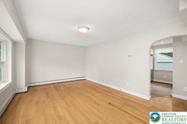 803 Stones Crossing Rd, Palmer Twp, PA 18045 - empty room with arched walkways, a baseboard heating unit, and light wood-style flooring