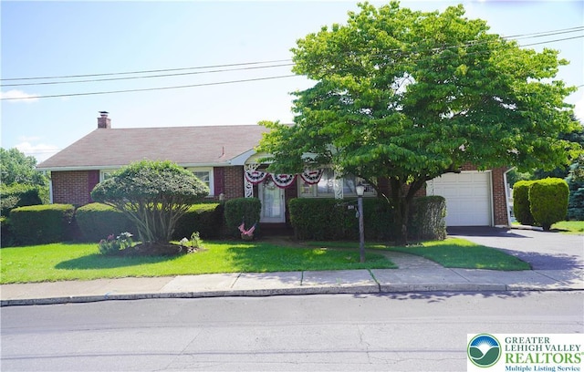 871 2nd St, Whitehall Twp, PA 18052 - view of front of home with brick siding, asphalt driveway, a garage, and a front lawn