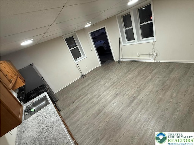 539 Atlantic Unit 3, Bethlehem Twp, PA 18015 - interior space featuring wood finished floors, a baseboard radiator, glass insert cabinets, and a drop ceiling