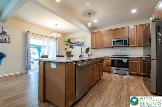 320 Bendelow Ln, Northampton Boro, PA 18067 - kitchen with stainless steel appliances, wood finished floors, brown cabinetry, a chandelier, and recessed lighting
