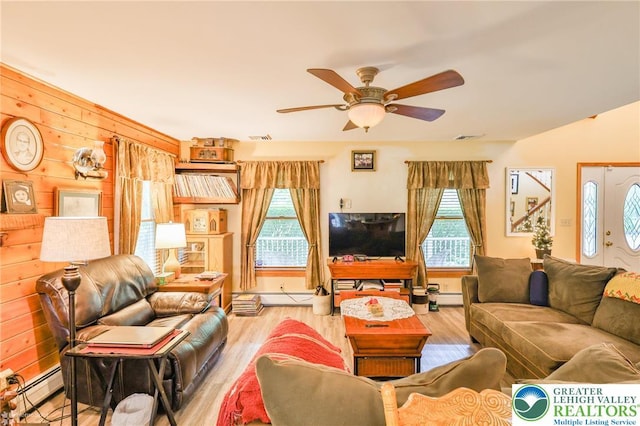 142 Hickory Ln, Chestnuthill Twp, PA 18353 - living room featuring a ceiling fan, wood finished floors, wood walls, a baseboard radiator, and baseboard heating