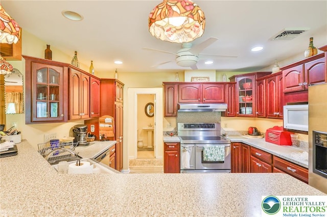 142 Hickory Ln, Chestnuthill Twp, PA 18353 - kitchen featuring stainless steel electric range, under cabinet range hood, white microwave, a ceiling fan, and dark brown cabinets