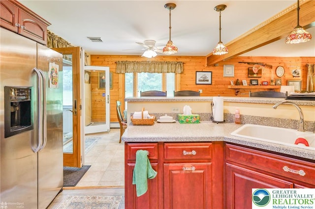 142 Hickory Ln, Chestnuthill Twp, PA 18353 - kitchen with stainless steel fridge, wooden walls, ceiling fan, pendant lighting, and light countertops