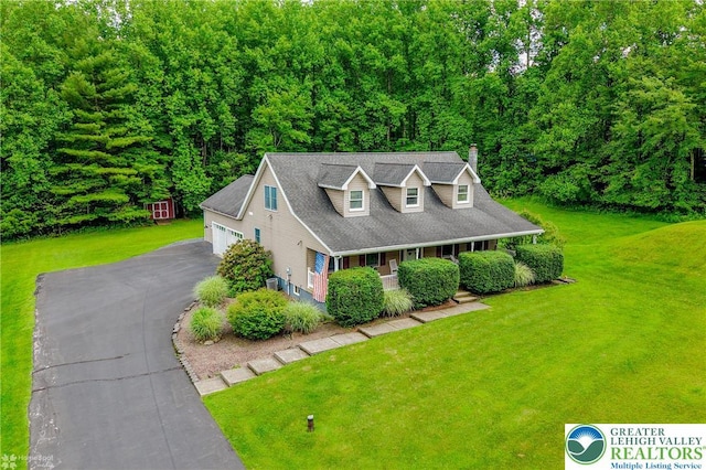 142 Hickory Ln, Chestnuthill Twp, PA 18353 - cape cod home with covered porch, a front yard, a chimney, an outdoor structure, and a wooded view
