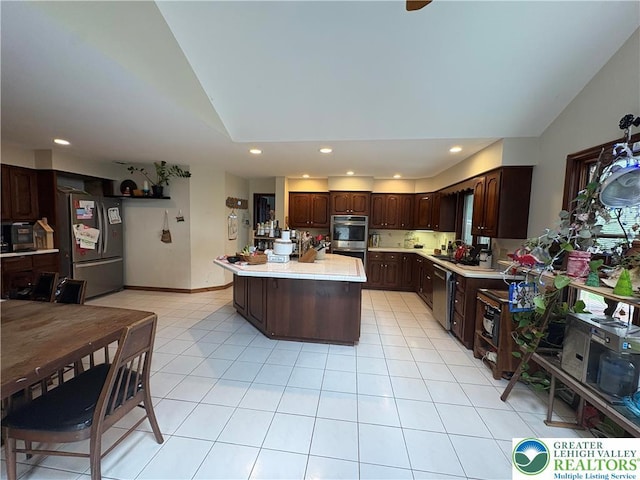 4804 Parkview Dr S, Lower Macungie Twp, PA 18049 - kitchen with stainless steel appliances, light countertops, dark brown cabinetry, a kitchen island, and light tile patterned floors