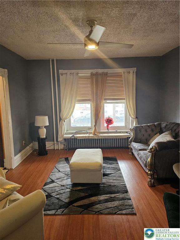 949 W Gordon St, Allentown City, PA 18102 - living room with radiator, a textured ceiling, wood finished floors, and ceiling fan