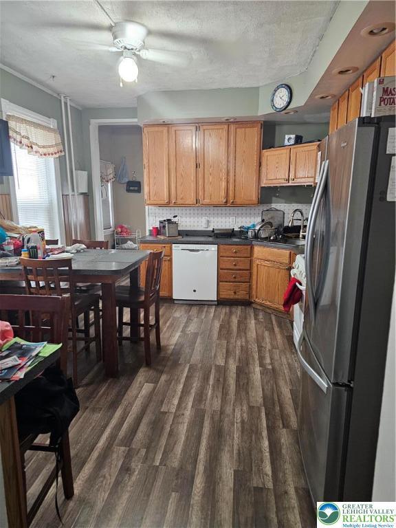 949 W Gordon St, Allentown City, PA 18102 - kitchen featuring freestanding refrigerator, dishwasher, dark wood-type flooring, dark countertops, and decorative backsplash