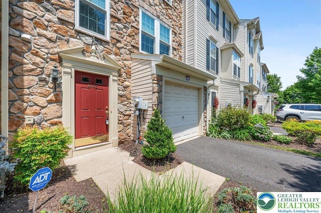 4583 Jasmine Dr, Upper Saucon Twp, PA 18034 - property entrance featuring stone siding, an attached garage, and driveway