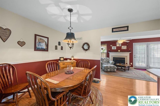 4583 Jasmine Dr, Upper Saucon Twp, PA 18034 - dining area with a ceiling fan, a wainscoted wall, a fireplace, light wood-type flooring, and healthy amount of natural light