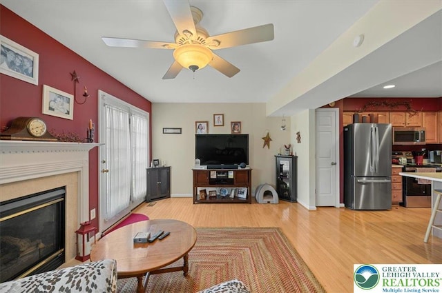 4583 Jasmine Dr, Upper Saucon Twp, PA 18034 - living room featuring light wood-style floors, a ceiling fan, and a glass covered fireplace