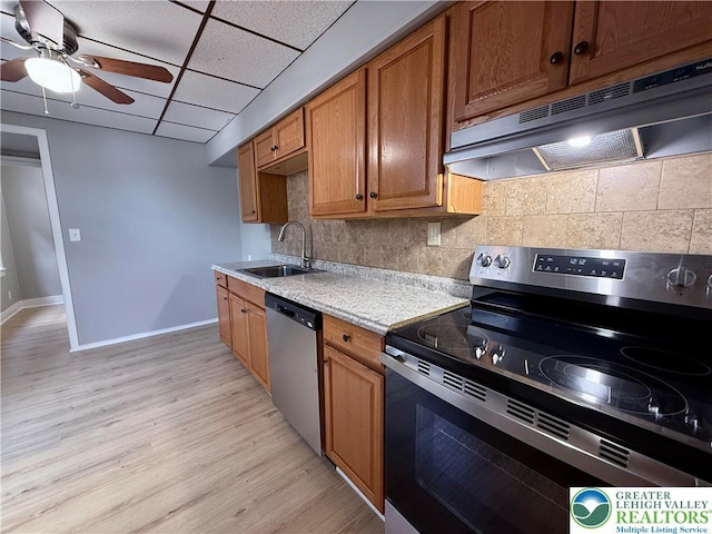 115 W Frankford St, Bethlehem City, PA 18018 - kitchen featuring stainless steel appliances, under cabinet range hood, light countertops, light wood-style floors, and backsplash
